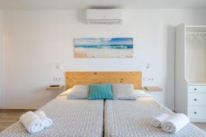 a bedroom with a bed with towels on it at Apartamentos Marivent in Portocolom