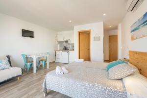 a bedroom with a bed and a couch and a table at Apartamentos Marivent in Portocolom