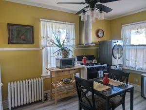 a kitchen with yellow walls and a table and a stove at Sunny & Spacious Montclair NJ Apartment in Montclair