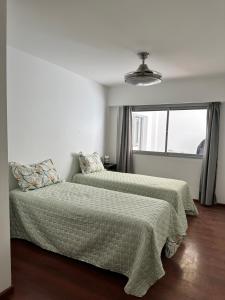 ein Schlafzimmer mit zwei Betten und einem Fenster in der Unterkunft Refugio Urbano in Neuquén