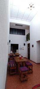 Habitación con mesa, bancos y techo. en Hotel Posada Don Papagon en Antigua Guatemala