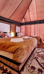 a bedroom with a large bed in a tent at Luxury Sahara Camp in Merzouga