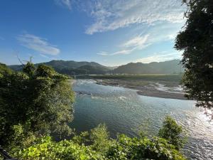 uitzicht op een rivier met bergen op de achtergrond bij Guest house HEART - Vacation STAY 98734v in Hitoyoshi