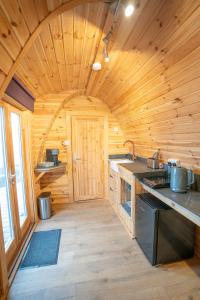 a kitchen in a wooden cabin with a stove at Sea View - Hot Tub, pet friendly in Barmouth