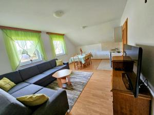 a living room with a blue couch and a kitchen at Apartman M. Rados in Kupres