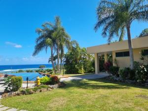 una casa con palmeras y piscina en Black Rock Villas en Rarotonga