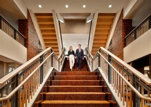 a man and a woman walking down stairs at The Charles Hotel in Harvard Square in Cambridge
