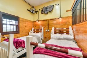 two twin beds in a room with wooden walls at Unique Stay Finger Lakes Converted Horse Barn in Rushville