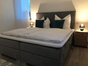 - une chambre dotée d'un grand lit avec des draps et des oreillers blancs dans l'établissement to be apartments Deluxe-Suites, à Weiden