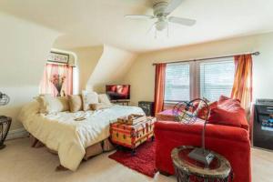 a bedroom with a bed and a red couch at 3rd Floor Cozy Unique Apt in Montclair