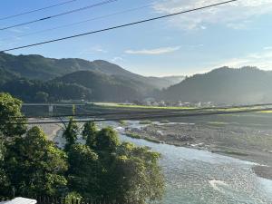 Guest house HEART - Vacation STAY 04732v في هيتويوشي: اطلالة على نهر مع جبال في الخلفية