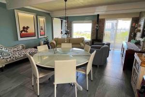 uma sala de jantar e sala de estar com mesa e cadeiras em Seaview Happy place em Bettyʼs Bay