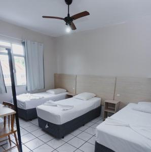 Habitación con 3 camas y ventilador de techo. en Ok Inn Hotel Floripa - SOB NOVA GESTÃO, en Florianópolis