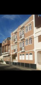 a large brick building with balconies on the side of it at Residencial/ Pensão Natur in Tarrafal