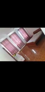 a living room with a window with pink curtains at Residencial/ Pensão Natur in Tarrafal