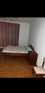 a bedroom with a bed and a table and a chair at Residencial/ Pensão Natur in Tarrafal