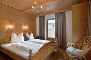 1 dormitorio con 1 cama, 1 silla y 1 lámpara de araña en Kashütte, en Hippach