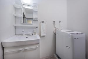 a white bathroom with a sink and a mirror at Shiki Homes | RURI - Vacation STAY 12774 in Osaka