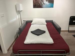 a bed in a room with a red and white blanket at Apartment Skógafoss in Skogar