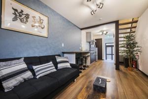 a living room with a black couch and a table at Shiki Homes | RURI - Vacation STAY 12774 in Osaka