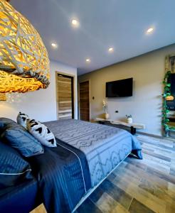 a bedroom with a blue bed and a television at Habitación Deluxe 1 con Jacuzzi a 20mt del parque in Salento