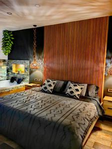 ein Schlafzimmer mit einem großen Bett und einem Kronleuchter in der Unterkunft Habitación Deluxe 1 con Jacuzzi a 20mt del parque in Salento