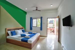 1 dormitorio con 1 cama con paredes azules y verdes en Abbi's Nest Beach House Goa, en Calangute