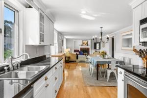 a kitchen with white cabinets and a dining room at 19 Burton Avenue West Harwich - - Lobsta House in West Harwich