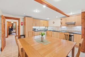 uma grande cozinha com uma mesa de madeira e cadeiras em Freuchies Mill - A Holiday Home For All Seasons. em Blairgowrie