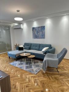 - un salon avec un canapé bleu et une table dans l'établissement Apartman 8, à Vrdnik