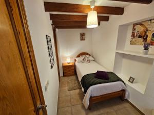 Dormitorio pequeño con cama y mesa en Casa Turistica Torreón de Villafamés en Villafamés