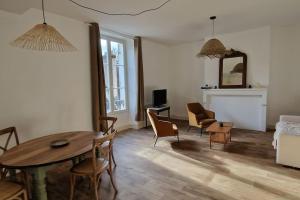 a living room with a dining room table and chairs at Au coin caché in Dole