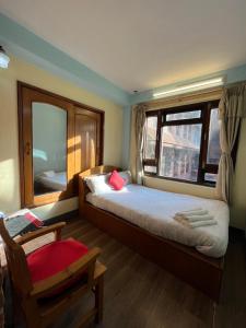 Un dormitorio con una cama grande y una ventana en Golden Gate Guest House, en Bhaktapur