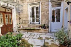 an entrance to a house with a door and plants at Au coin caché in Dole