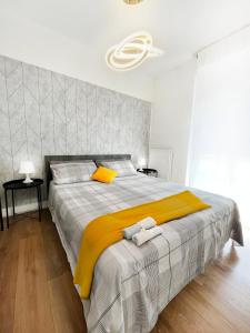SuitesFlores - Bright and cozy apartment in Verona في فيرونا: غرفة نوم بسرير كبير مع بطانية صفراء