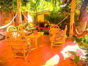um pátio com cadeiras, uma mesa e uma rede de descanso em Art & Coffee em Santa Cruz La Laguna