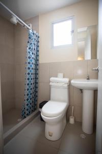 a bathroom with a toilet and a sink at COMODO DEPARTAMENTO CERCA DE LA PLAYA WIFFI in Tonsupa
