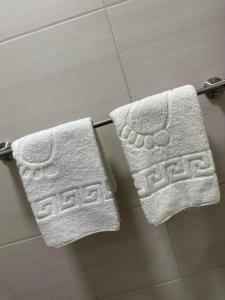 - 2 serviettes suspendues à un porte-serviettes dans la salle de bains dans l'établissement Apartman 8, à Vrdnik