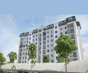 a large white building with trees in front of it at Deluxe Apartment in Tashkent