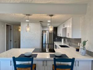 uma cozinha com armários brancos e uma ilha com cadeiras em Pasado Del Rio, Downtown getaway em Lake Havasu City