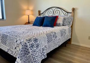 Cama con sábanas y almohadas azules y blancas en Pasado Del Rio, Downtown getaway en Lake Havasu City