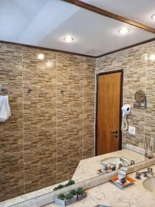 W łazience znajduje się prysznic, umywalka i lustro. w obiekcie Flat Pancetti w mieście Belo Horizonte