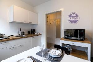 門興格拉德巴赫的住宿－2 Zi Wohnung inkl WLAN NETFLIX 3D Tour，厨房配有白色橱柜和带微波炉的桌子。