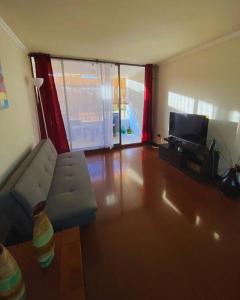 ein Wohnzimmer mit einem Sofa und einem Flachbild-TV in der Unterkunft Apartamento en Iquique in Iquique