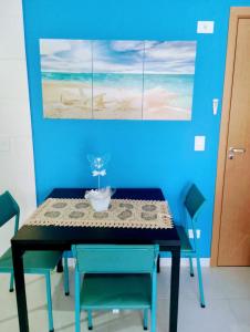 ein Esszimmer mit einem Tisch mit Stühlen und einem Gemälde in der Unterkunft Apartamento 2 quartos próximo da praia in Praia Grande
