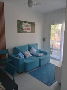 ein blaues Sofa im Wohnzimmer mit Fenster in der Unterkunft Apartamento 2 quartos próximo da praia in Praia Grande