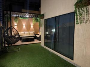 برج كابانا للوحدات السكنية في الرياض: غرفة معيشة مع أرضية خضراء على جانب مبنى