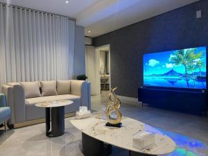 a living room with a couch and a large tv at برج كابانا للوحدات السكنية in Riyadh