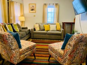 sala de estar con 2 sillas y sofá en Cozy First Floor Apartment en Chicopee