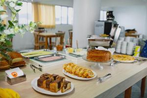 a table with several different types of bread and pastries at Ok Inn Hotel Floripa in Florianópolis